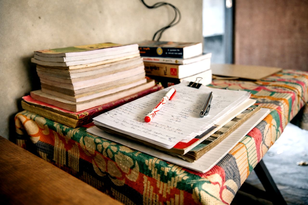 A cluttered study desk with notebooks and pens, creating a warm and intellectual ambiance.